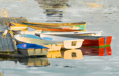 Colorful dinghy dock of Red and blue dinghies in golden afternoon light.  Has a feeling of quiet and yet it smells  fresh like the sea at high tide.